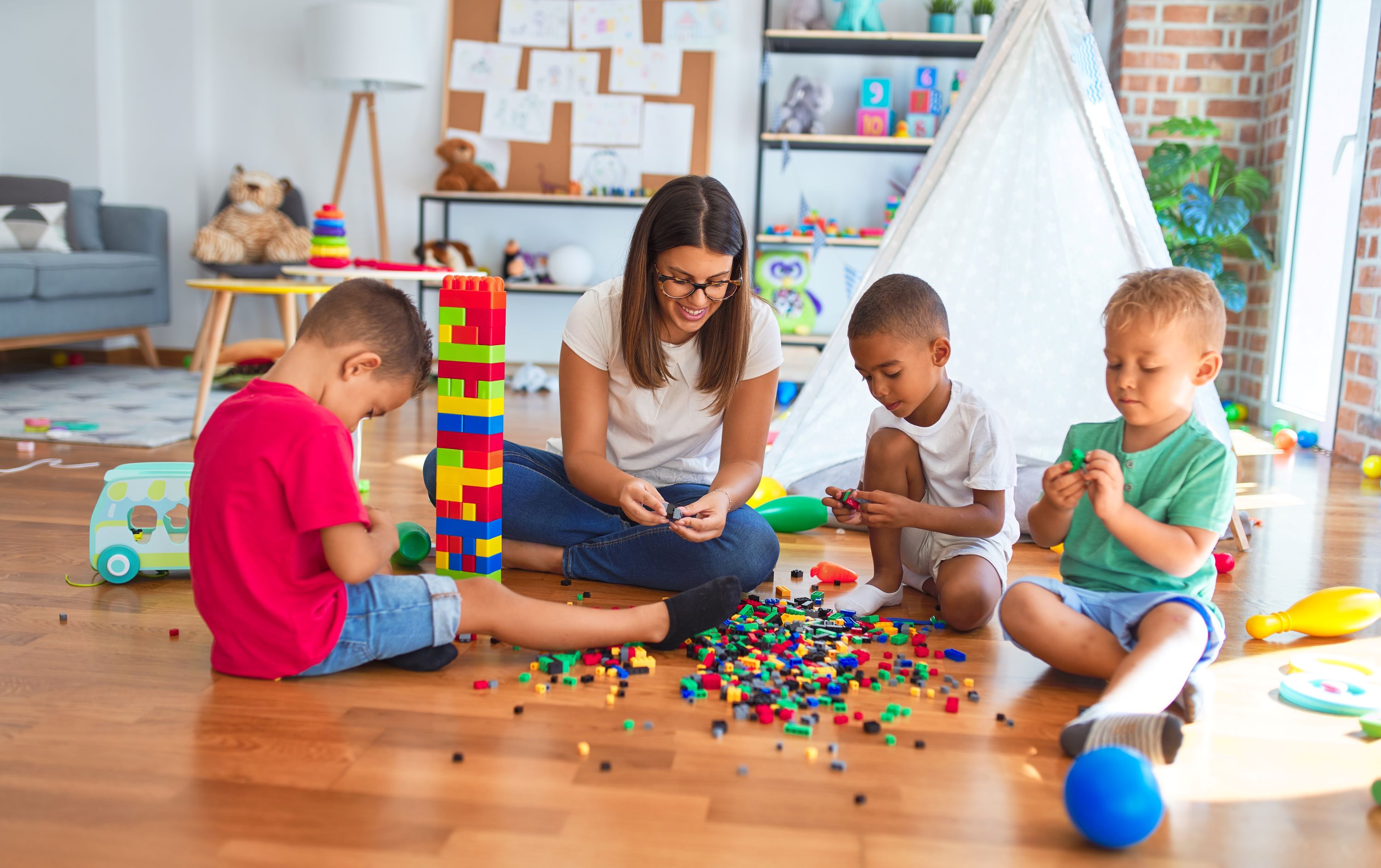 Woman's and three children playing with legos