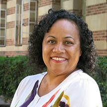 Headshot of a woman standing in front of a building, smiling