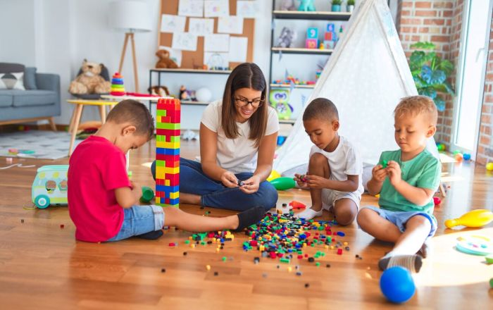 Woman and three children playing with legos